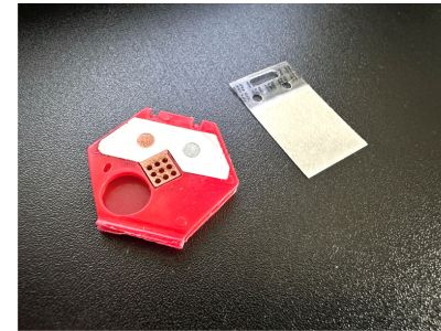 The internal components of the Luxel badge. The white strip is the dosimeter that absorbs radiation.