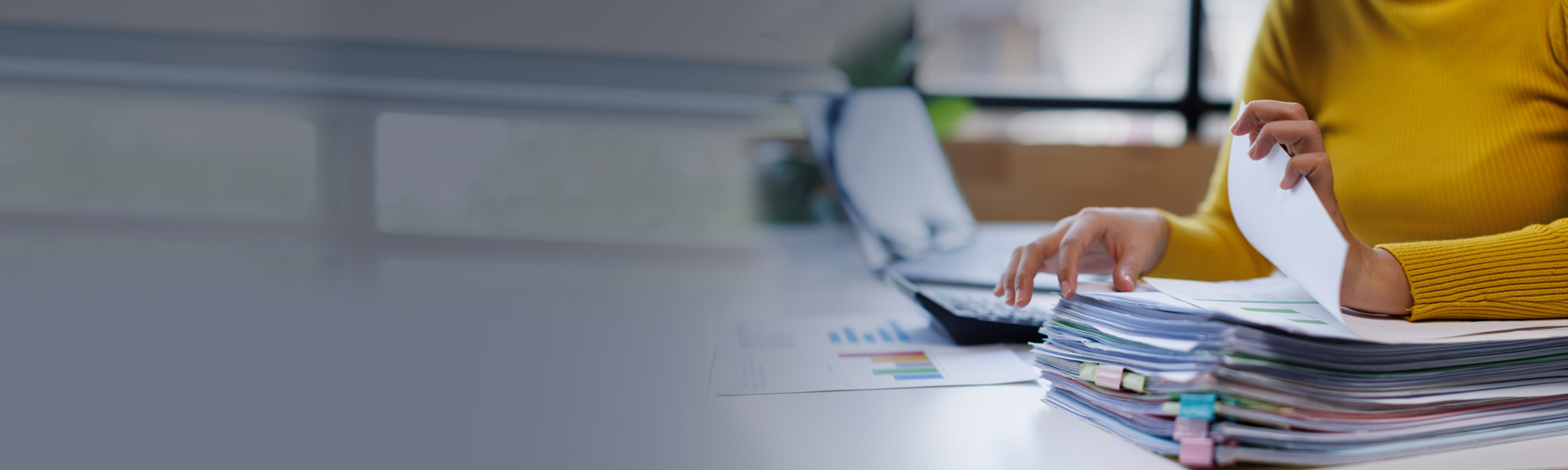 Worker organizing a large stack of documents 